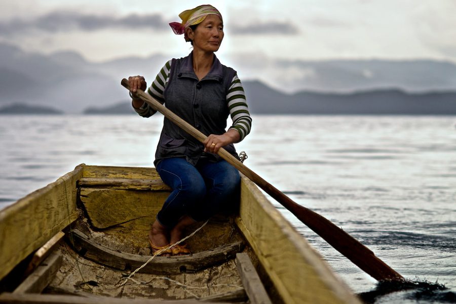 Mosuo woman on the lake in a boat